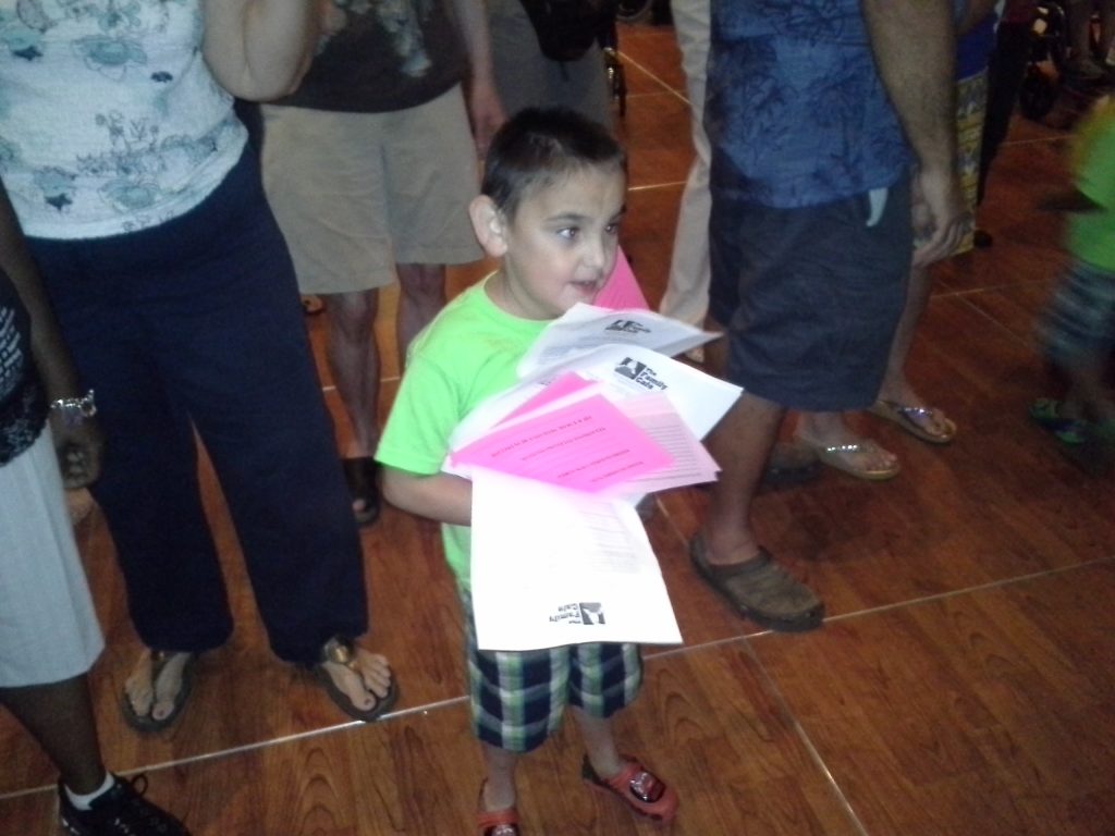 Kid holding an armful of pink cards and report cards.
